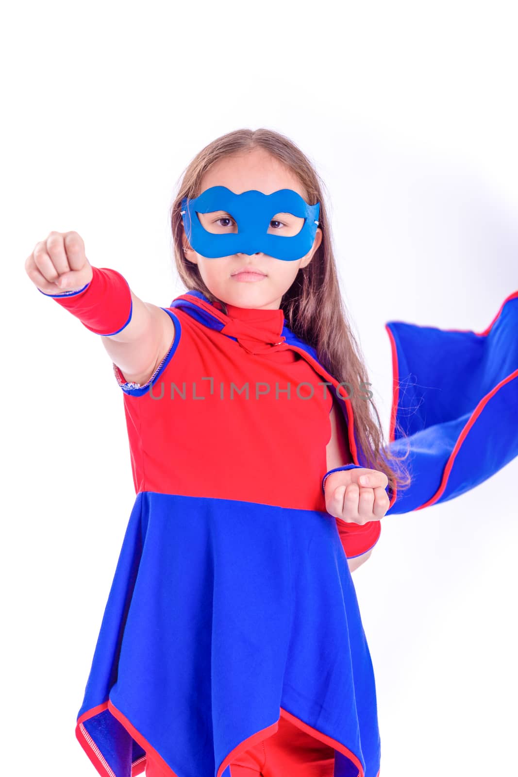 Young female child in blue and red superhero outfit with arm extended in flying pose