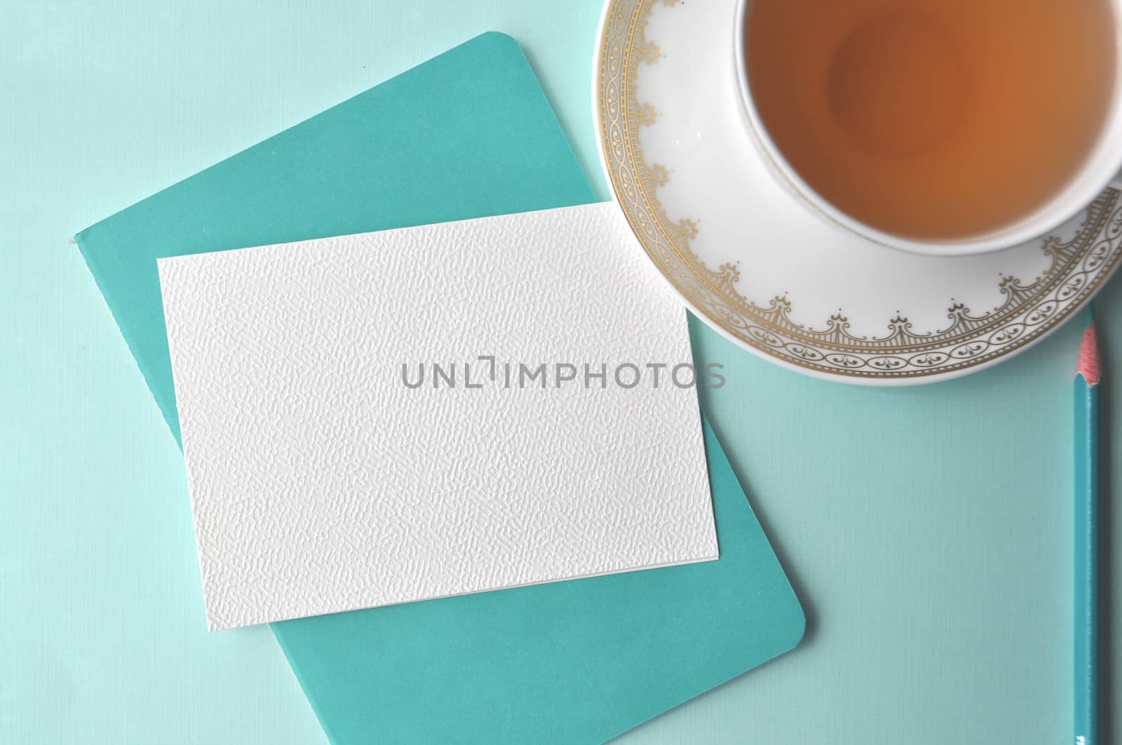 A cup of tea on aqua teal mint background with copy space on a blank note card