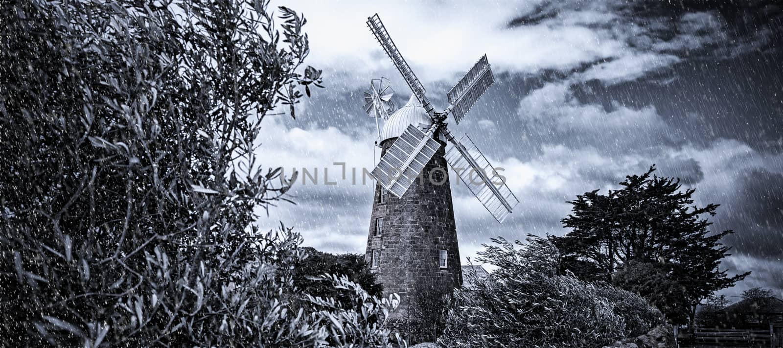 Windmill in the countryside covered in artificial rain and snow. by artistrobd