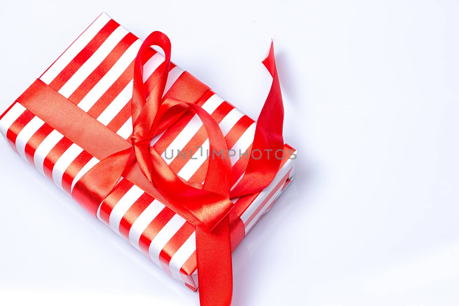 Red gift box with ribbon on white