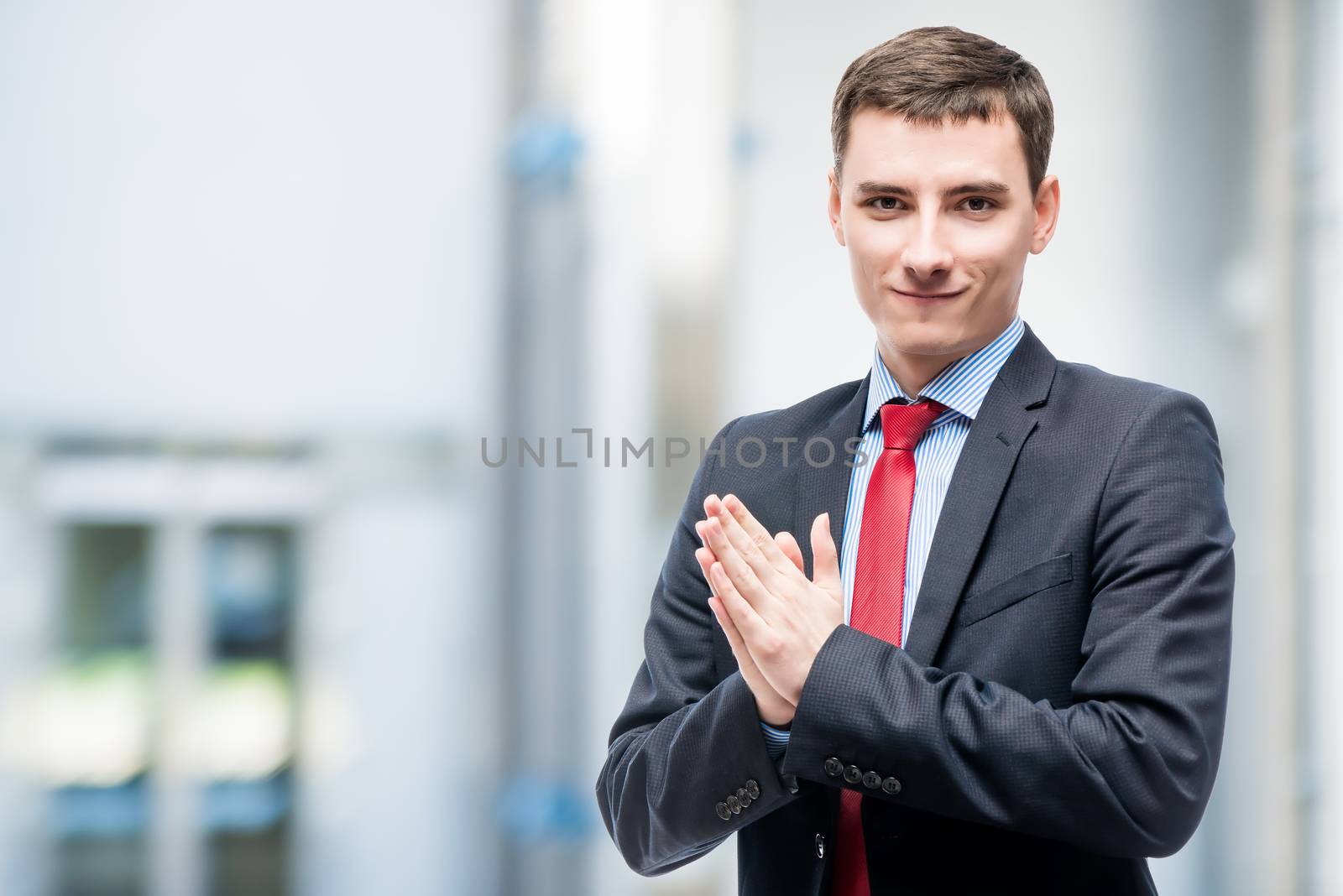 Young successful businessman in office, space left