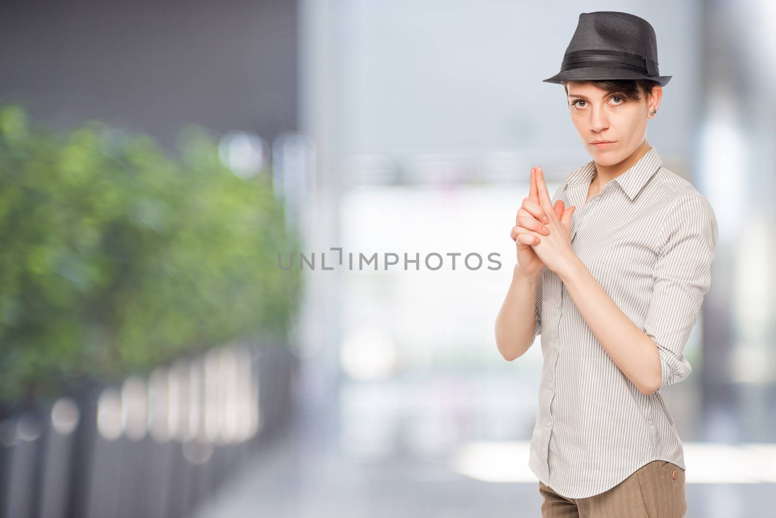 Detective woman thumbs gun in the office