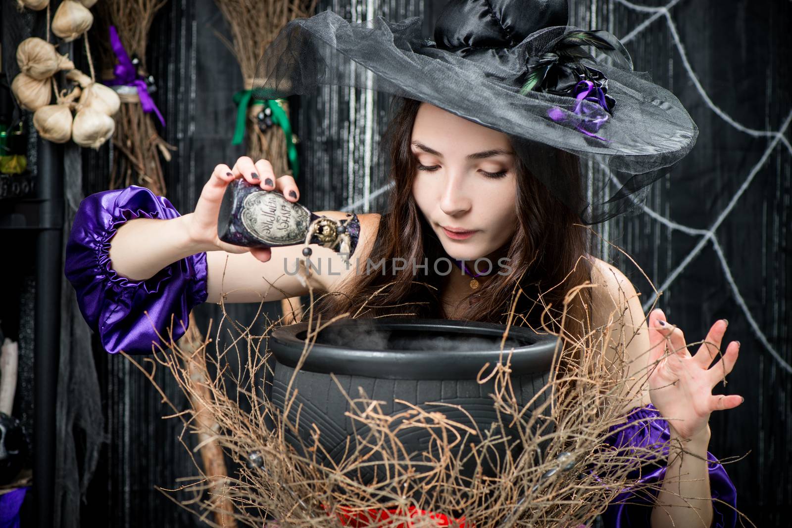 witch in a black hat in a pot cooks a potion