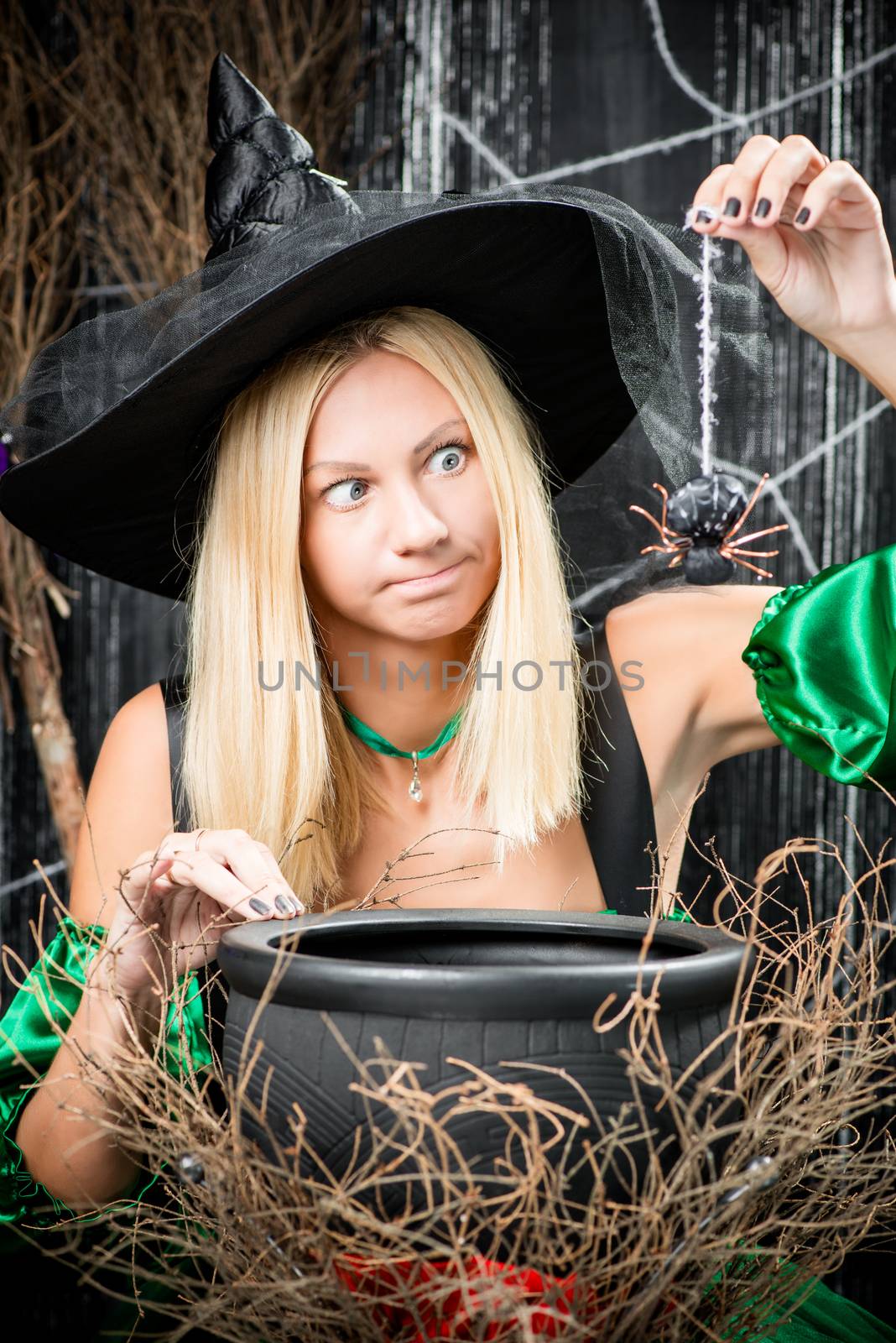 Experienced young witch casts into the cauldron spider