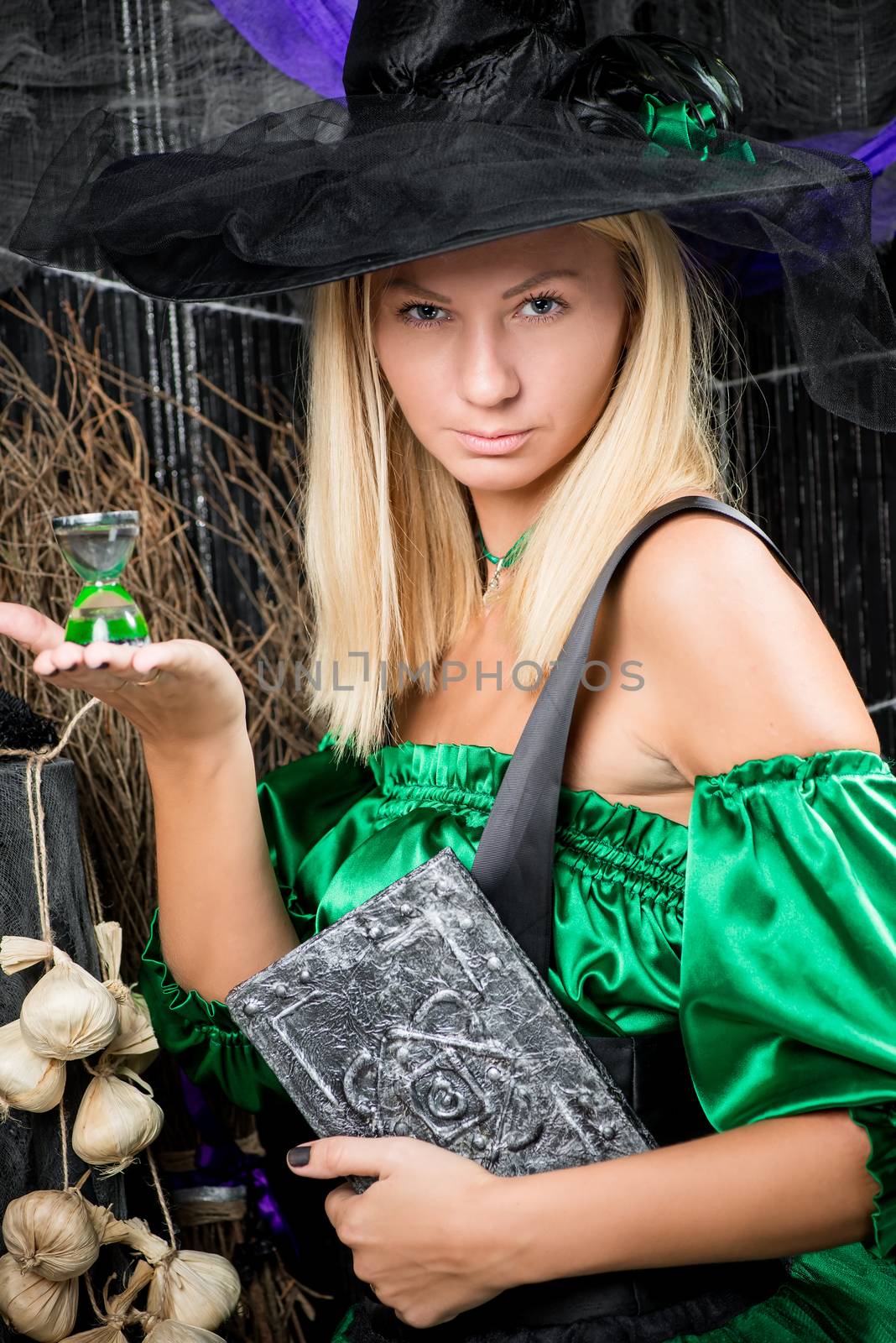 vertical portrait of a beautiful witch with a magic book in his hands