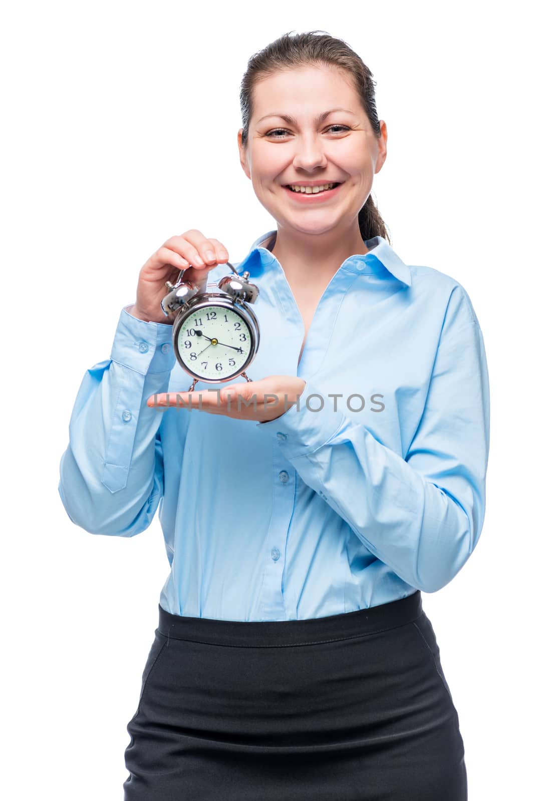 Vertical portrait of businesswoman in blue shirt with alarm clock on white background