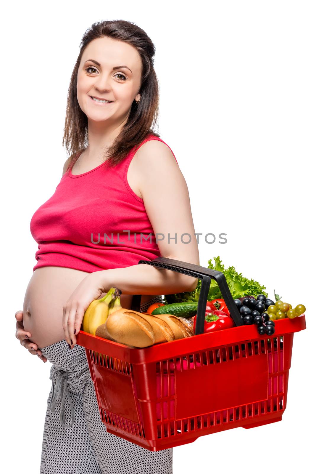 Young pregnant woman with basket of fruits and vegetables on white background isolated