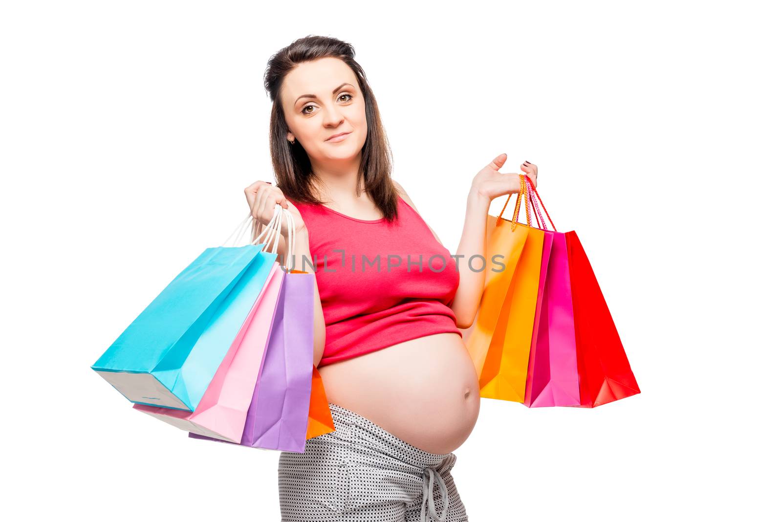 On white background portrait of pregnant woman with packages for shopping