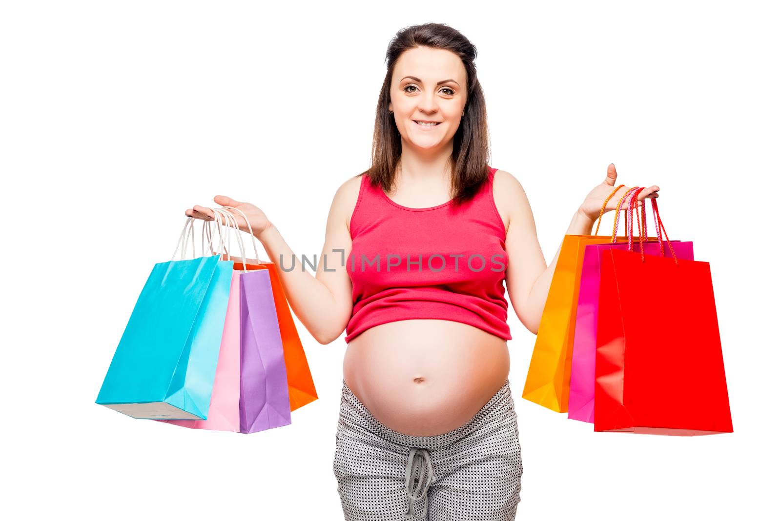 Portrait of a happy and beautiful future mother with shopping on a white background