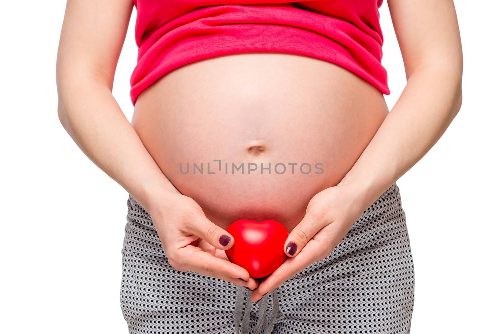 red heart shape on background of pregnant female belly closeup by kosmsos111