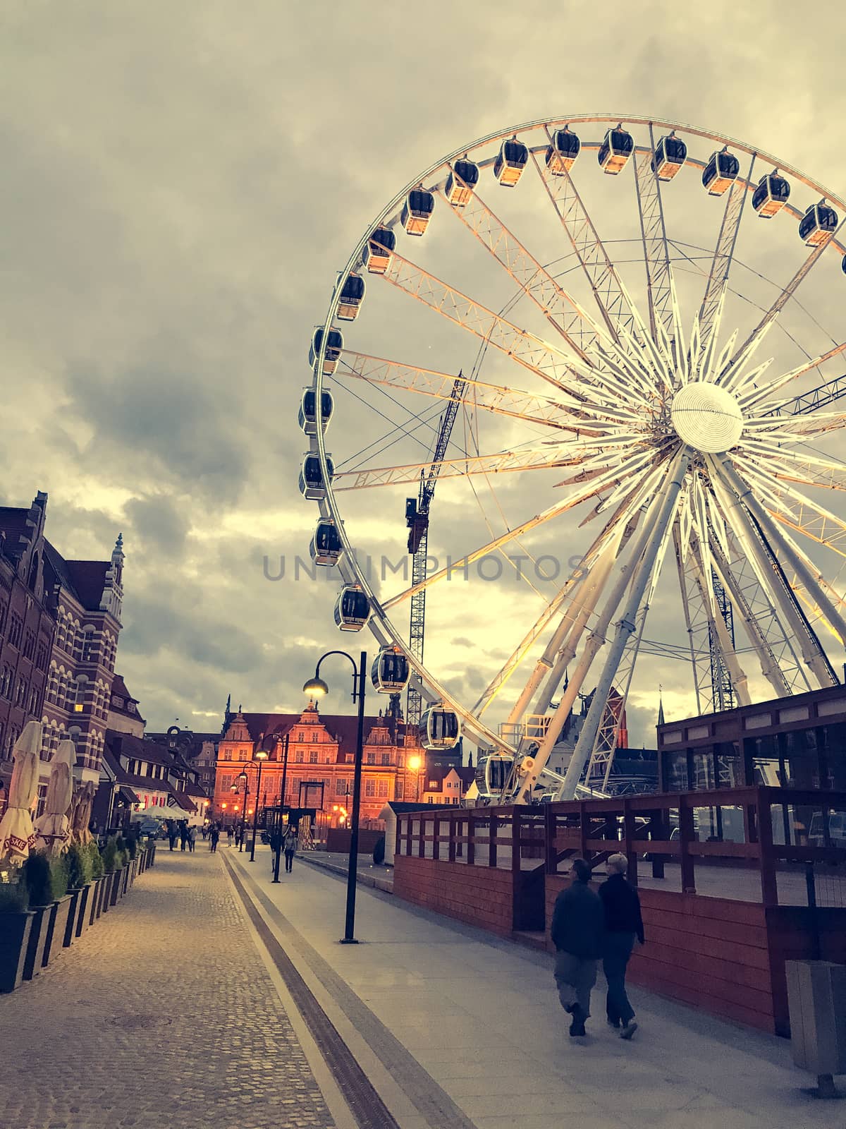 Great evening Ferris wheel in Gdansk, Poland against the background of old cityscape