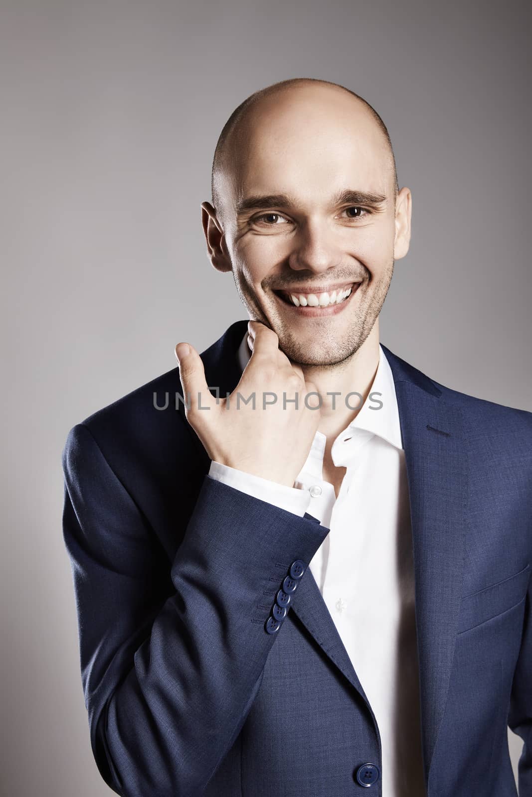 Portrait of handsome cheerful man stroking his chin.