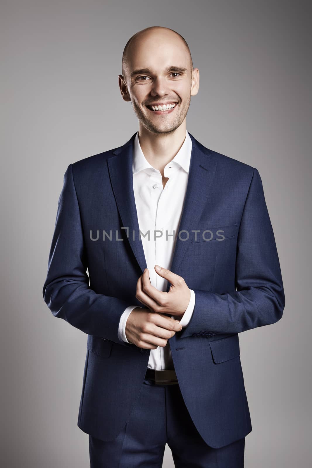 Portrait of young businessman fixing cufflinks his suit.