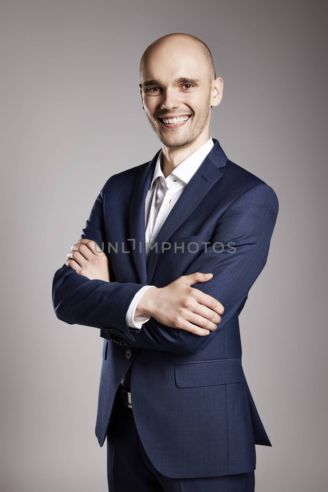 Portrait of Smiling Businessman with Arms Crossed. 