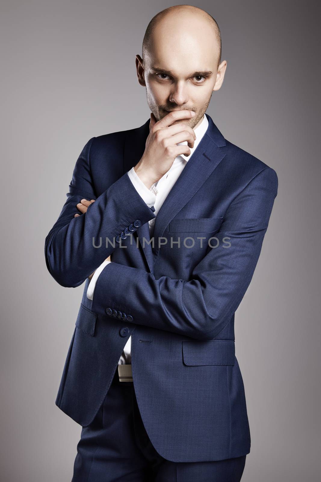 Portrait of young bald businessman looking at camera.