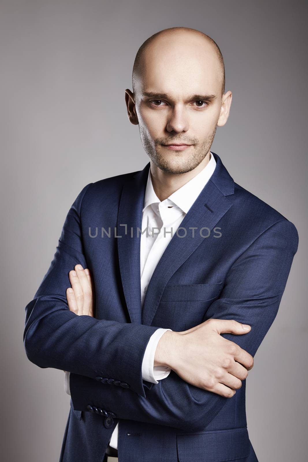 Portrait of young bald businessman looking at camera.