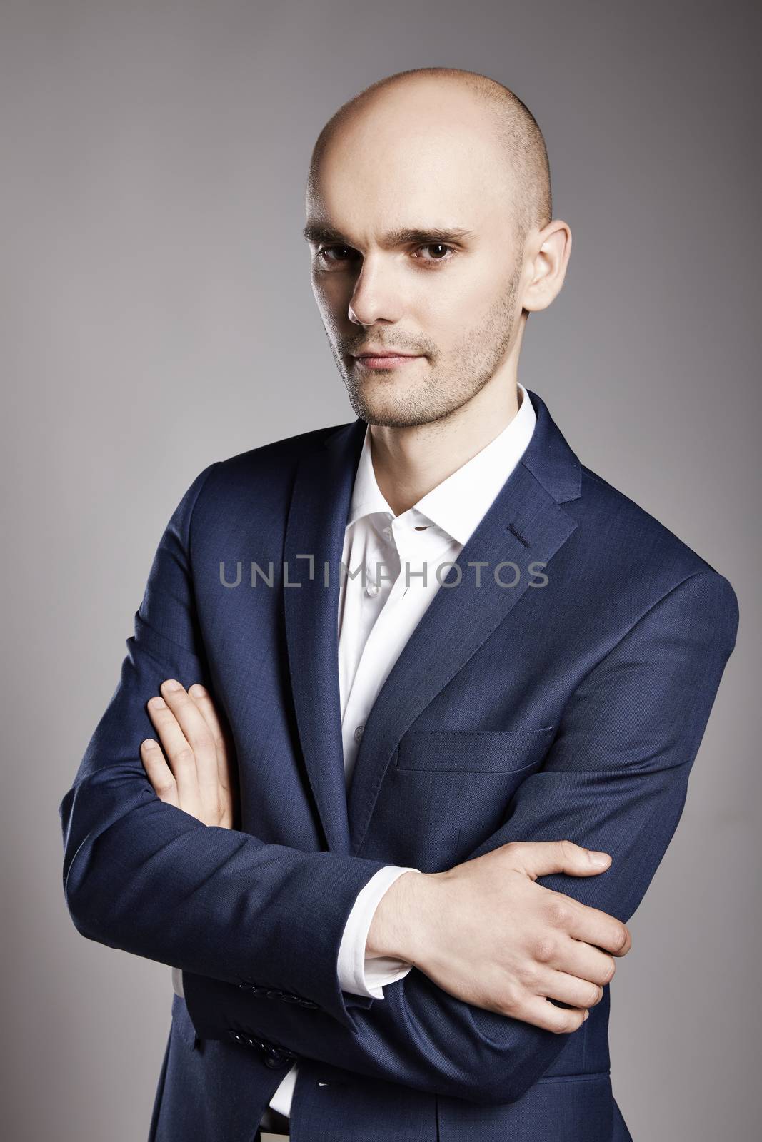 Portrait of young bald businessman looking at camera.