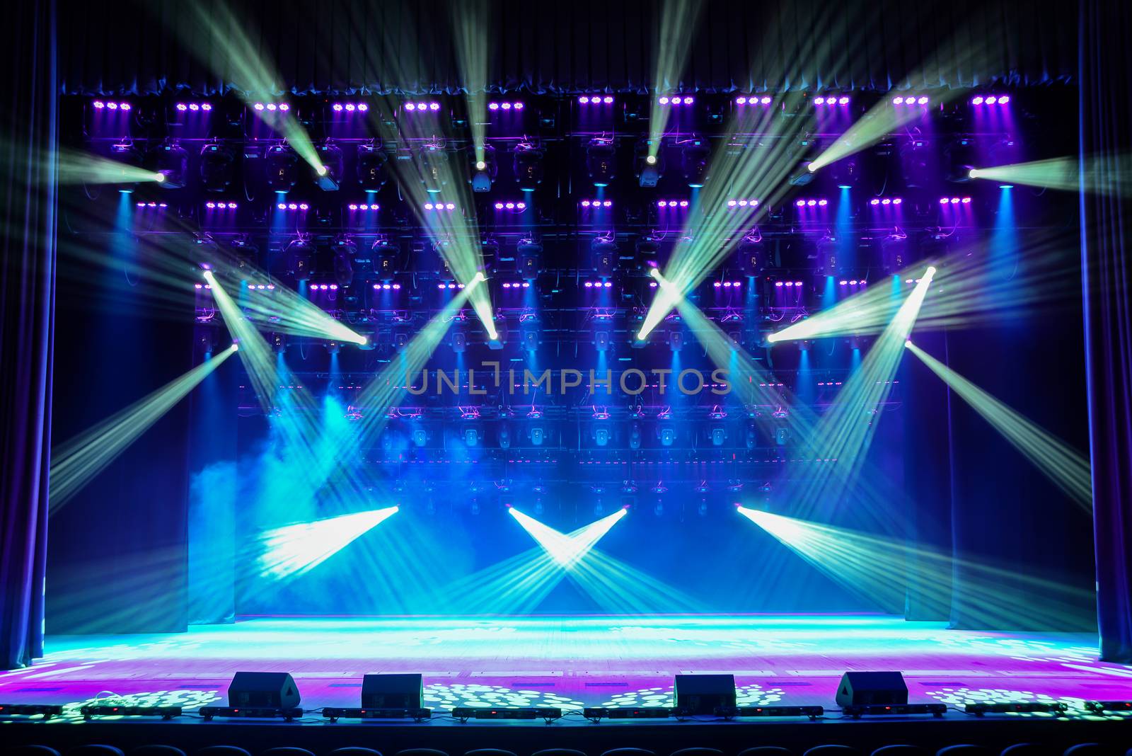 Illuminated empty show stage with blue light and stage fog