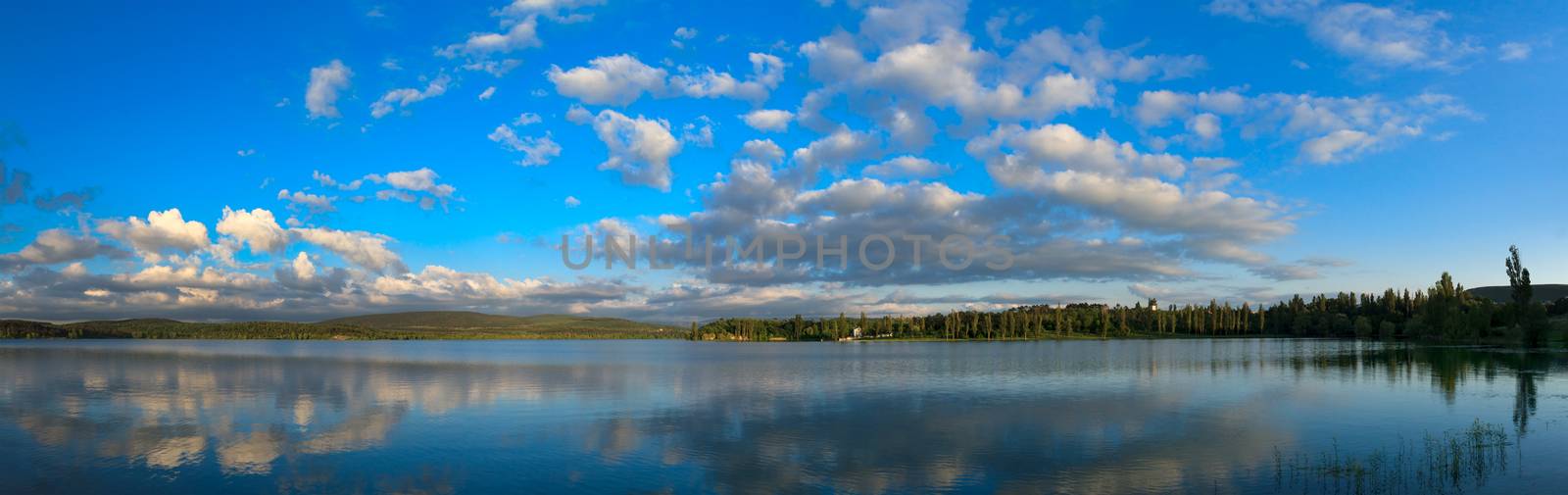 Blue sky with sun over water. by fogen