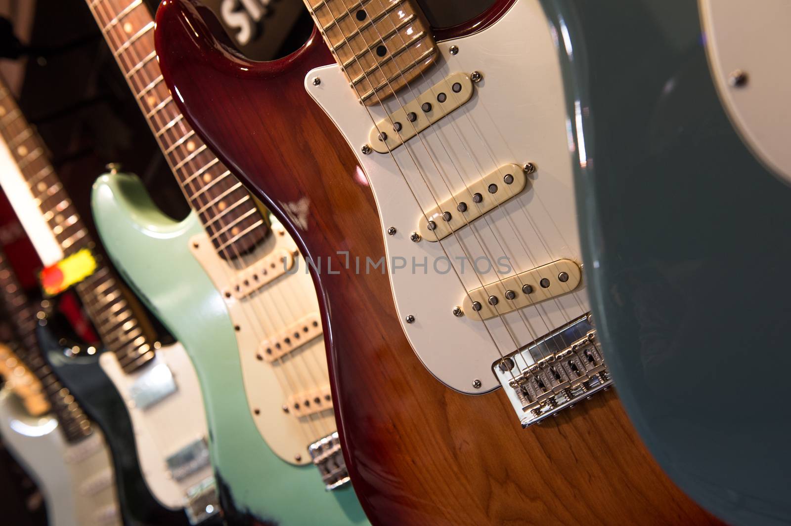 Many electric guitars hanging on wall in the shop, France