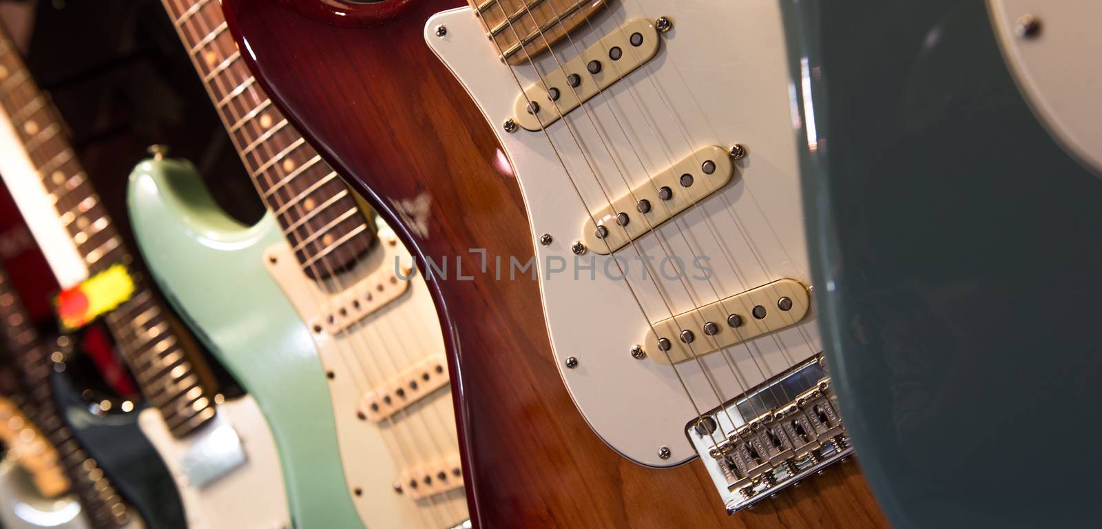 Many electric guitars hanging on wall in the shop, France