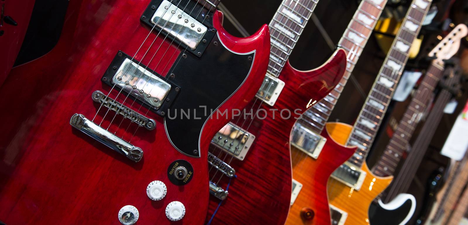 Many electric guitars hanging on wall in the shop, France