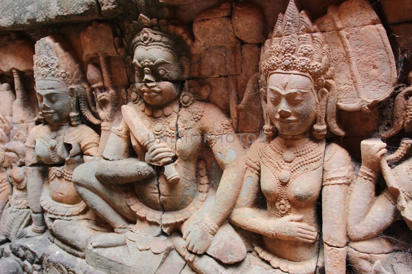 A beautiful ancient relief on the wall of a Cambodian Buddhist temple from Angkor complex, near the antique city of Siem Reap.