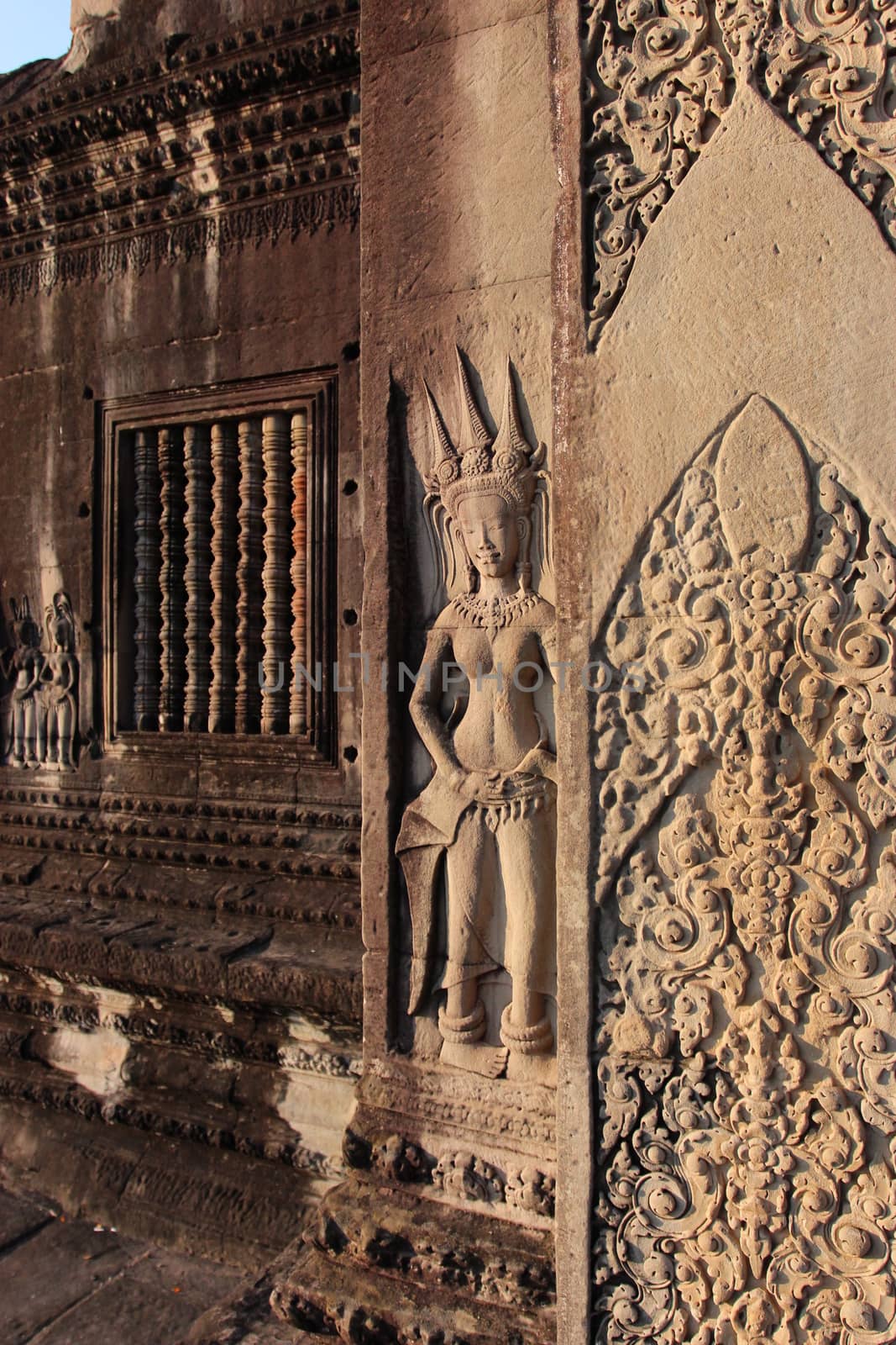 A beautiful ancient relief on the wall of a Cambodian Buddhist temple from Angkor complex, near the antique city of Siem Reap.