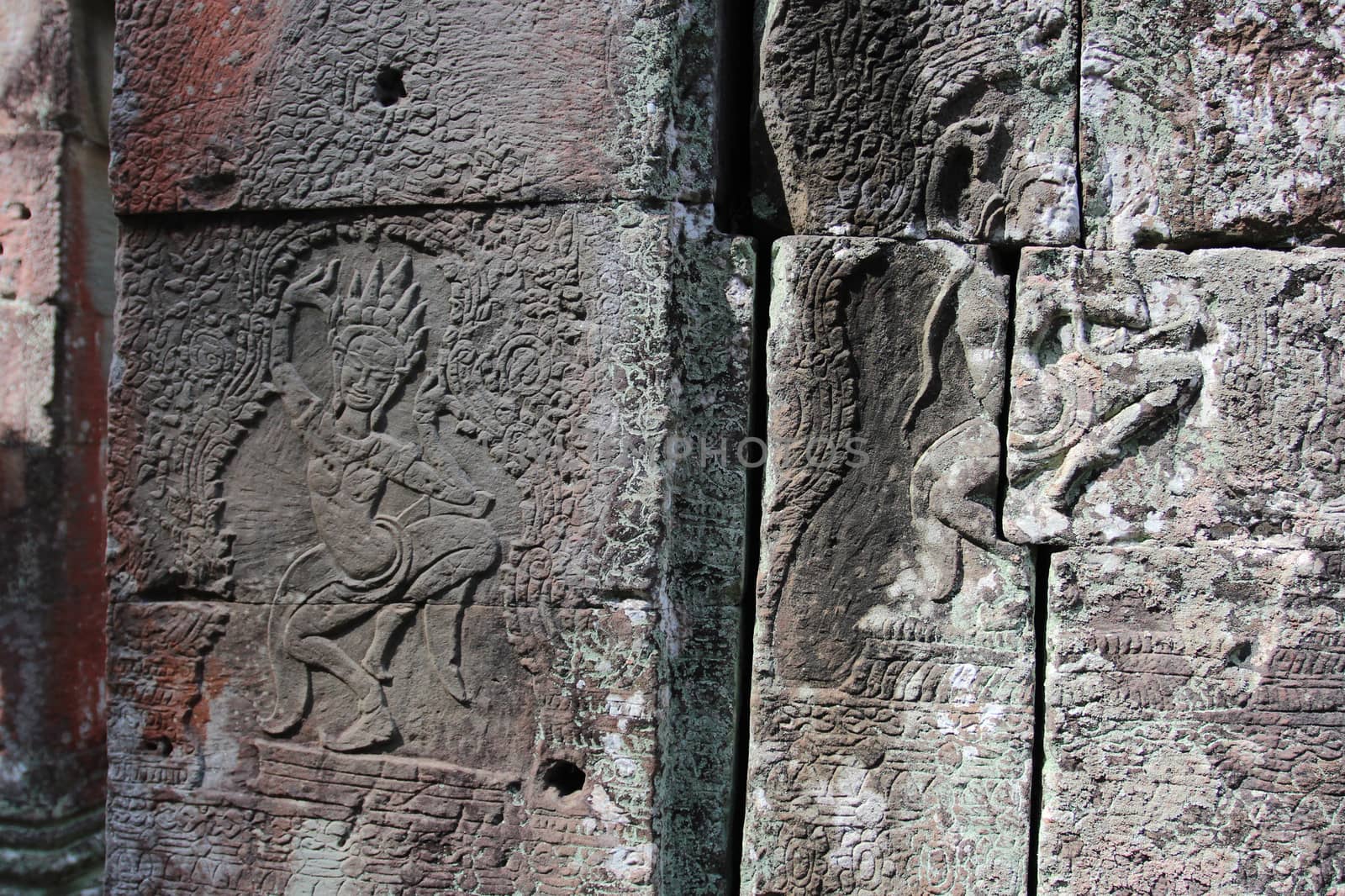 A beautiful ancient relief on the wall of a Cambodian Buddhist temple from Angkor complex, near the antique city of Siem Reap.
