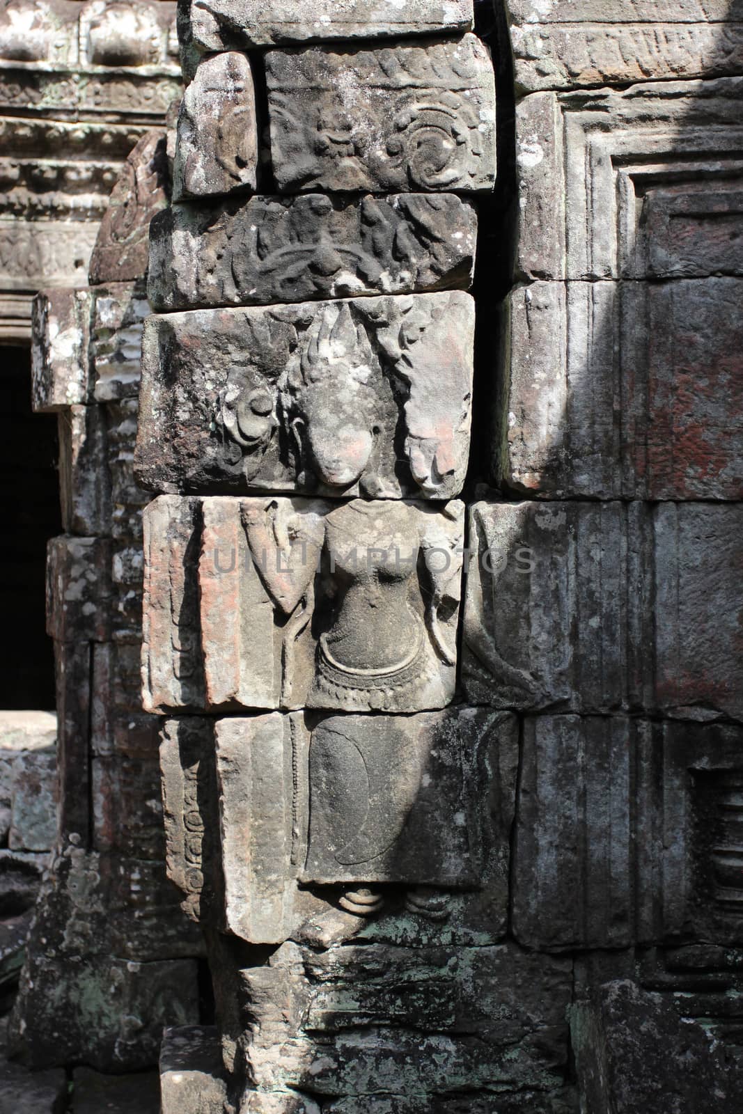 A beautiful ancient relief on the wall of a Cambodian Buddhist temple from Angkor complex, near the antique city of Siem Reap.