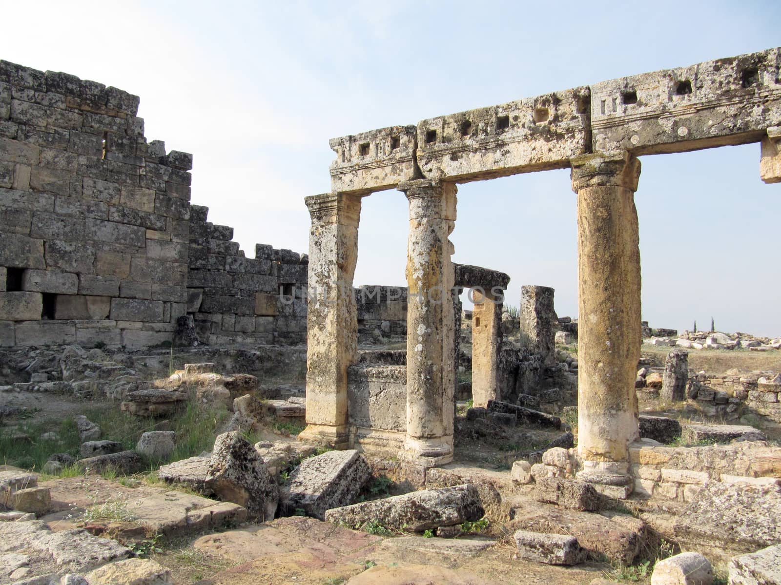 The ruins of an ancient Greek city in the background of hills and green cypresses. Turkey