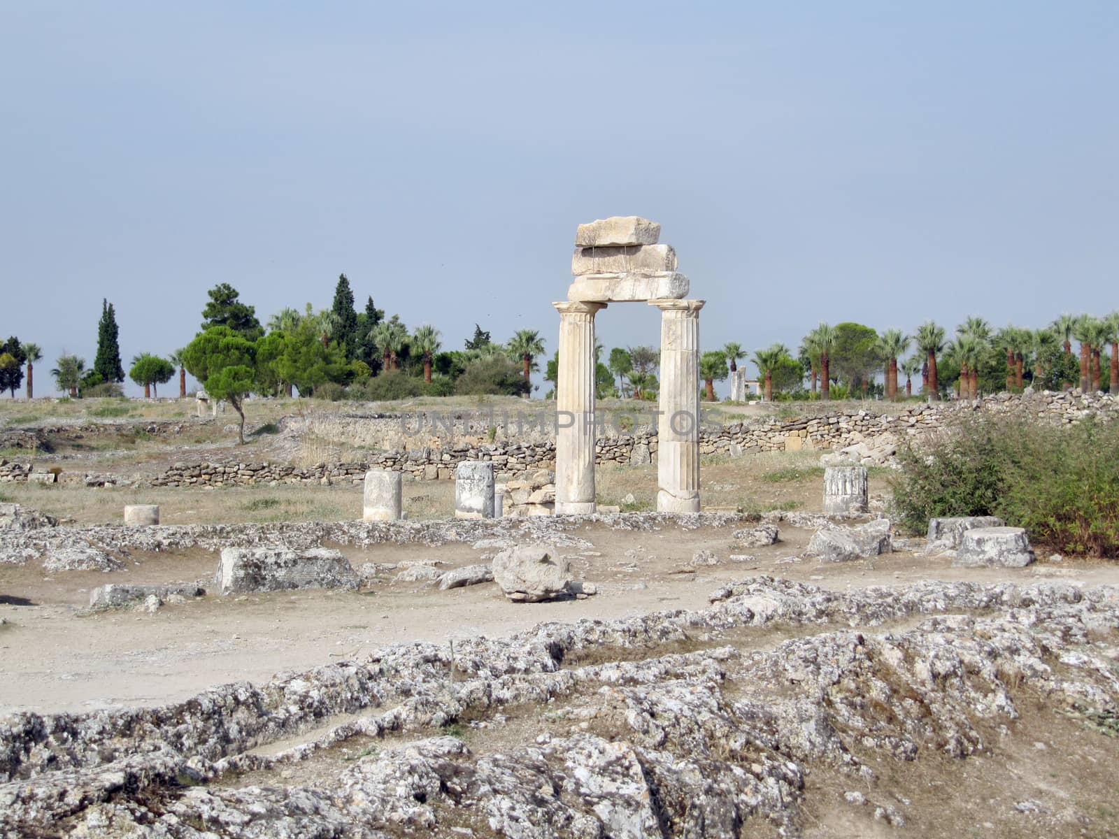 The ruins of an ancient Greek city in the background of hills and green cypresses. Turkey