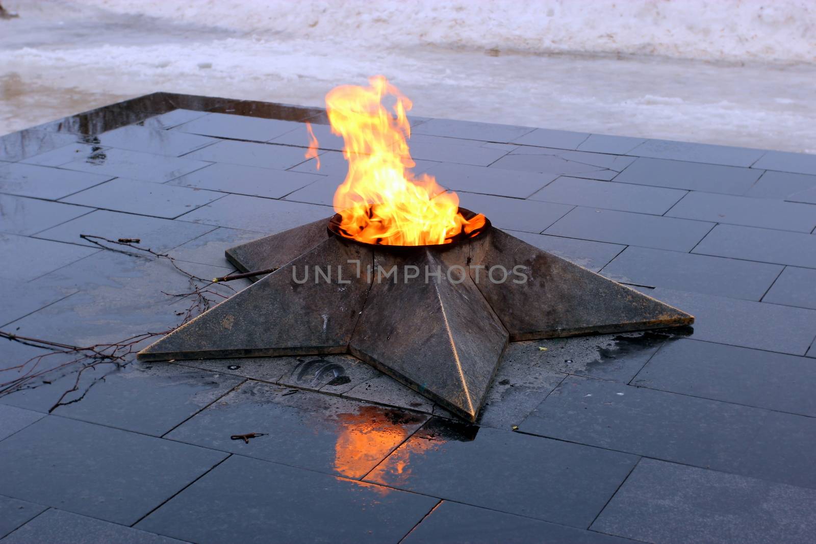 Close image of eternal fire in the form of a star on a marble pedestal