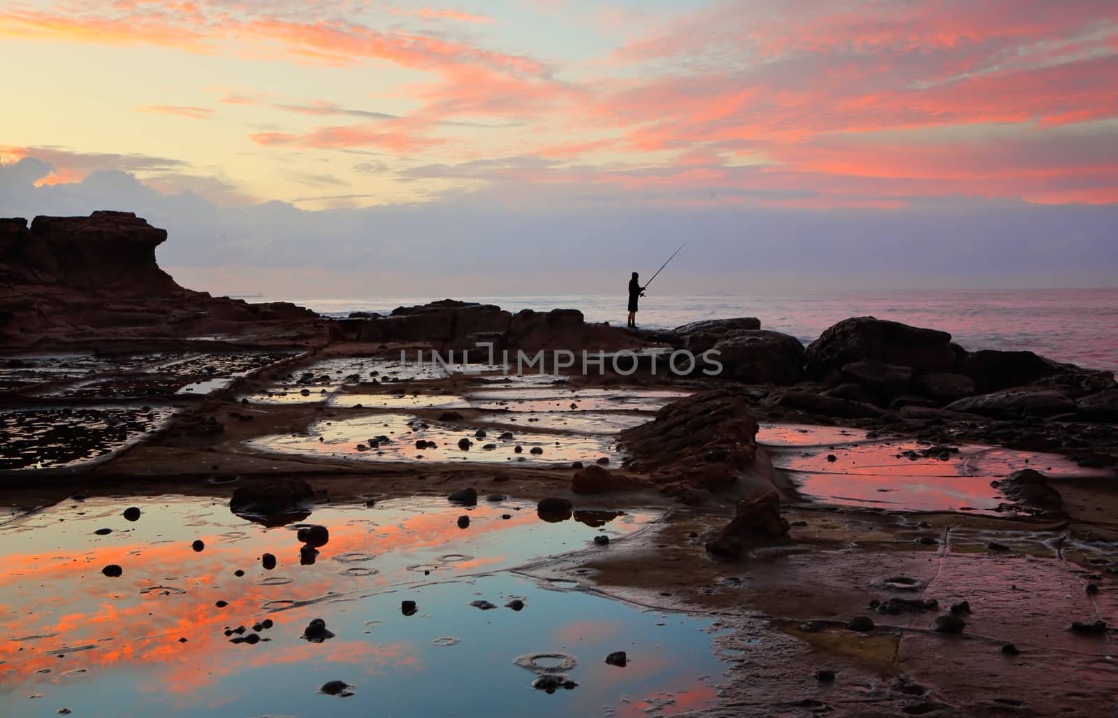 Low tide reflections of sunrise on the rock shelf.  Wollongong NSW Australia