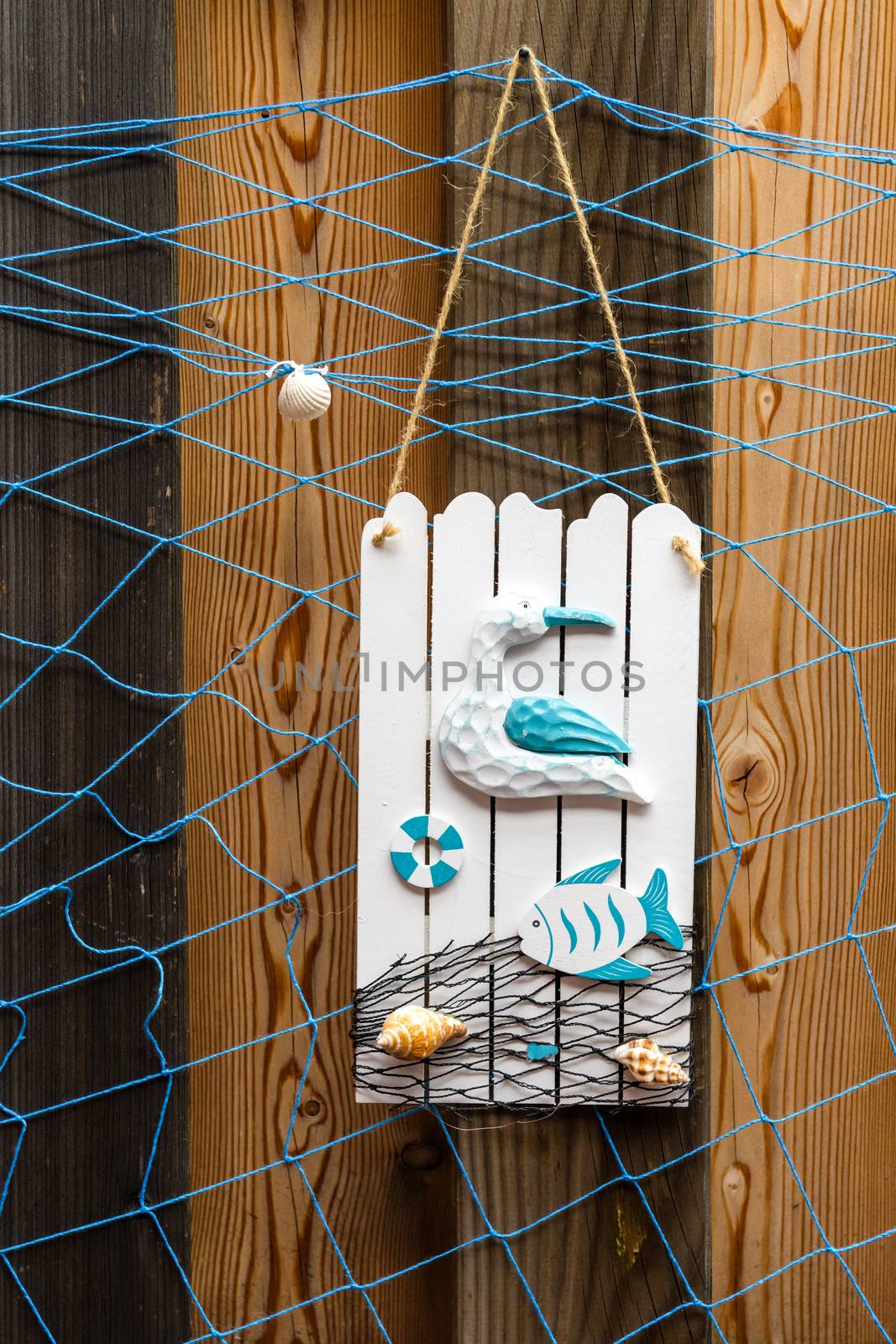 Summer beach style decoration with shells, seagull and fish on weathered wooden background by asafaric