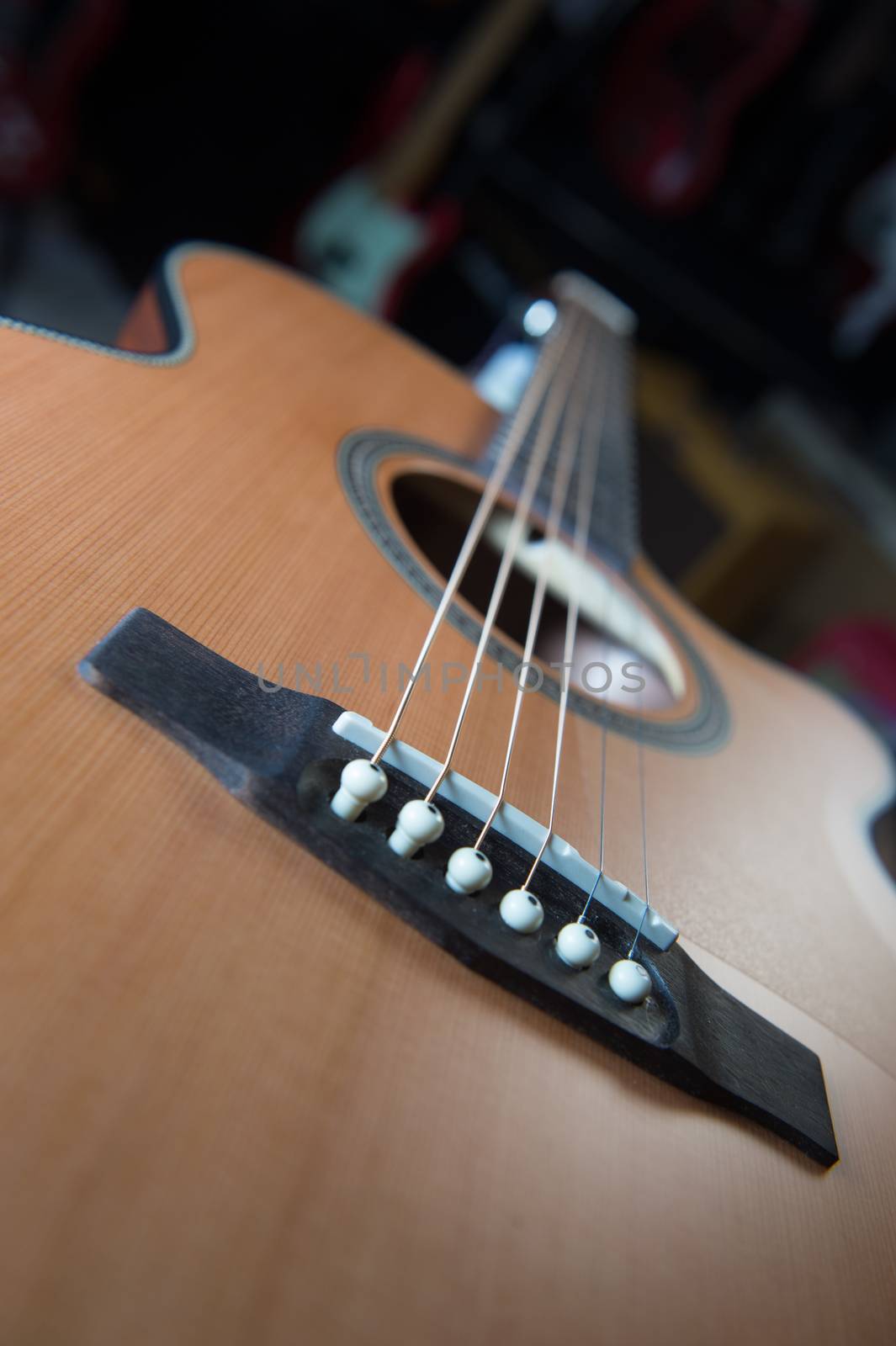 Macro shot down the fretboard of acoustic guitar with shallow depth of field, France