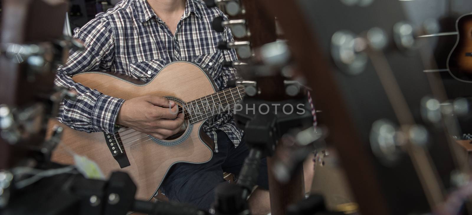 Young man playing the guitar in a shop, France