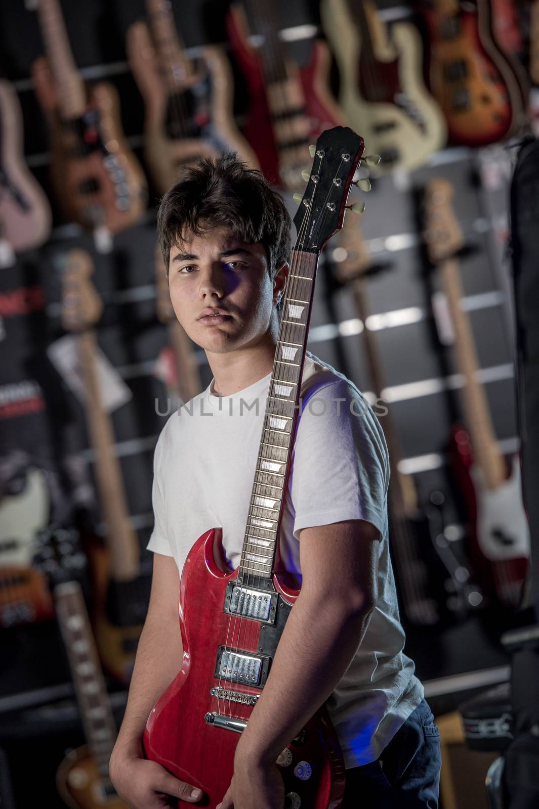 Young man playing the guitar in a shop, France