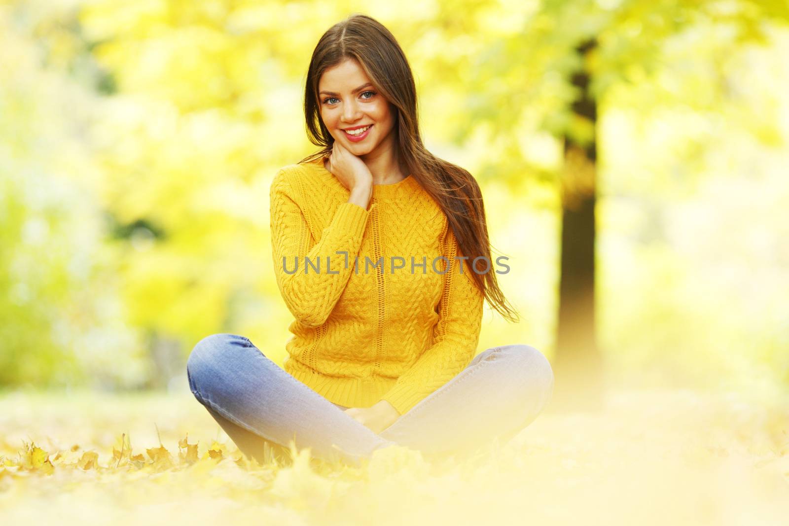 Woman sitting on autumn leaves by Yellowj