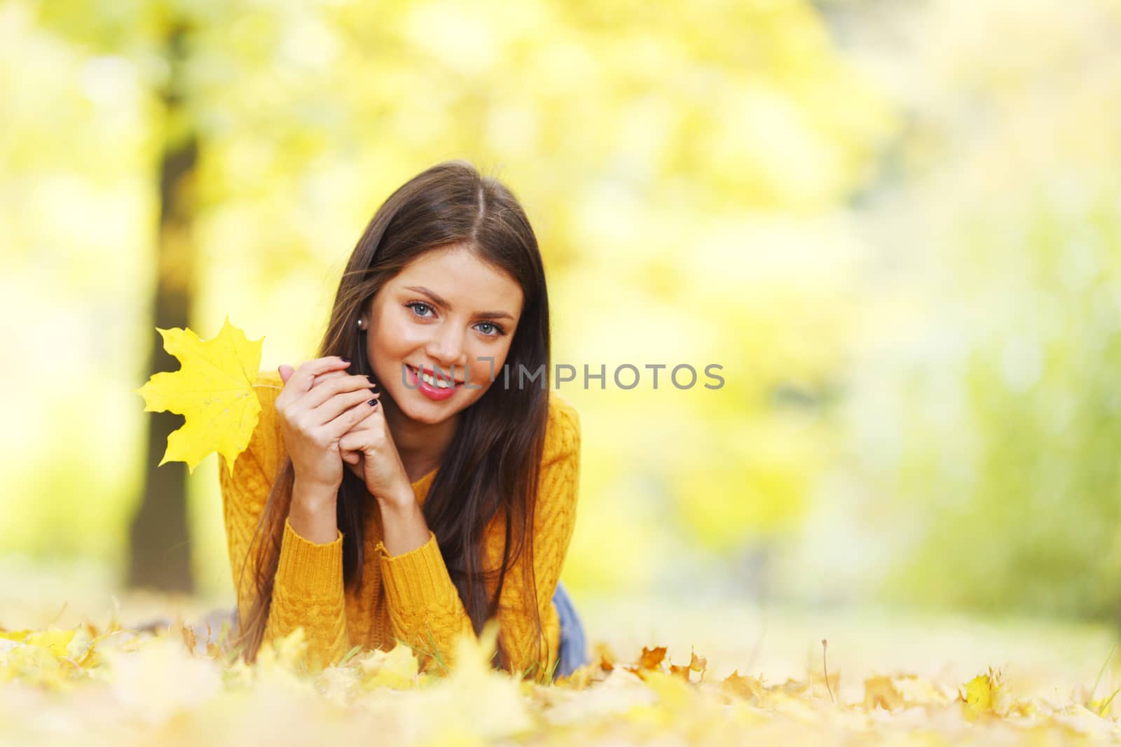 Cute woman laying in autumn park by Yellowj