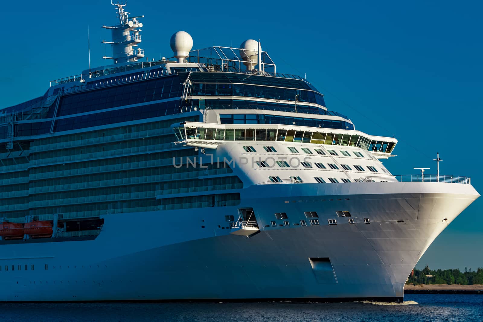 White giant brand new passenger ship moving in clear summer day