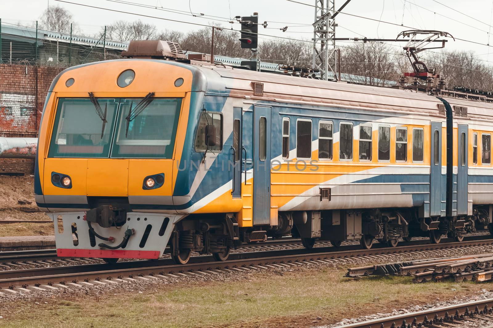 Yellow modern passenger electric train moving at the old terminal