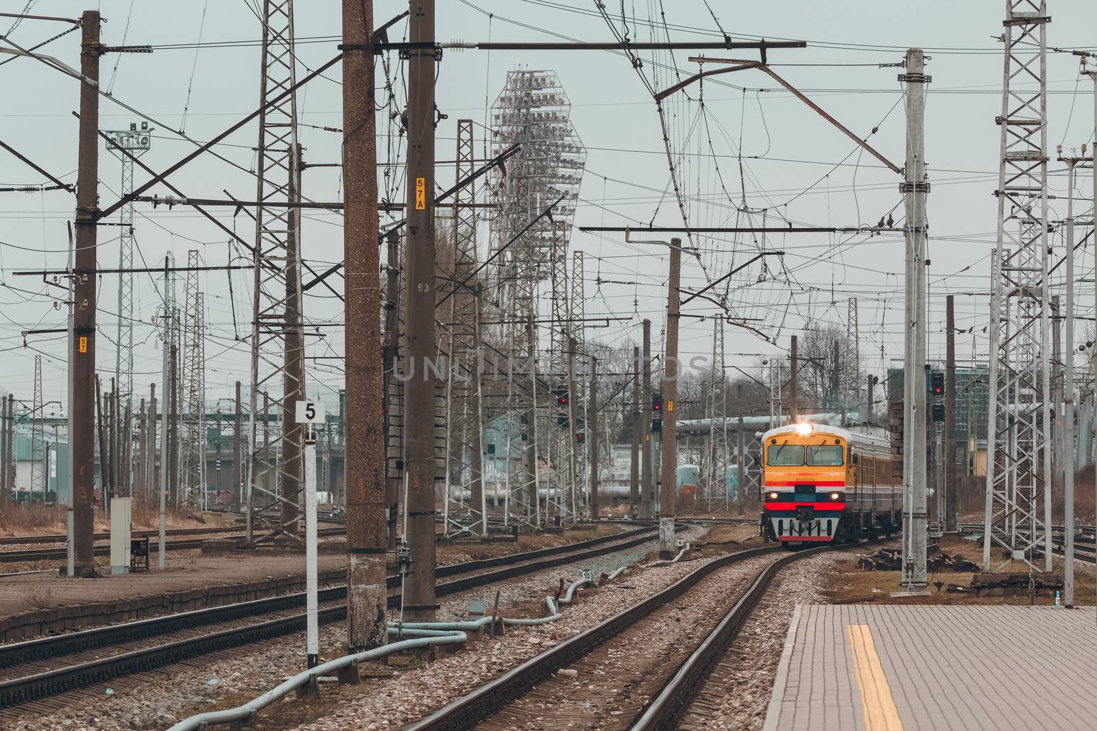 Old yellow passenger diesel train moving at the terminal