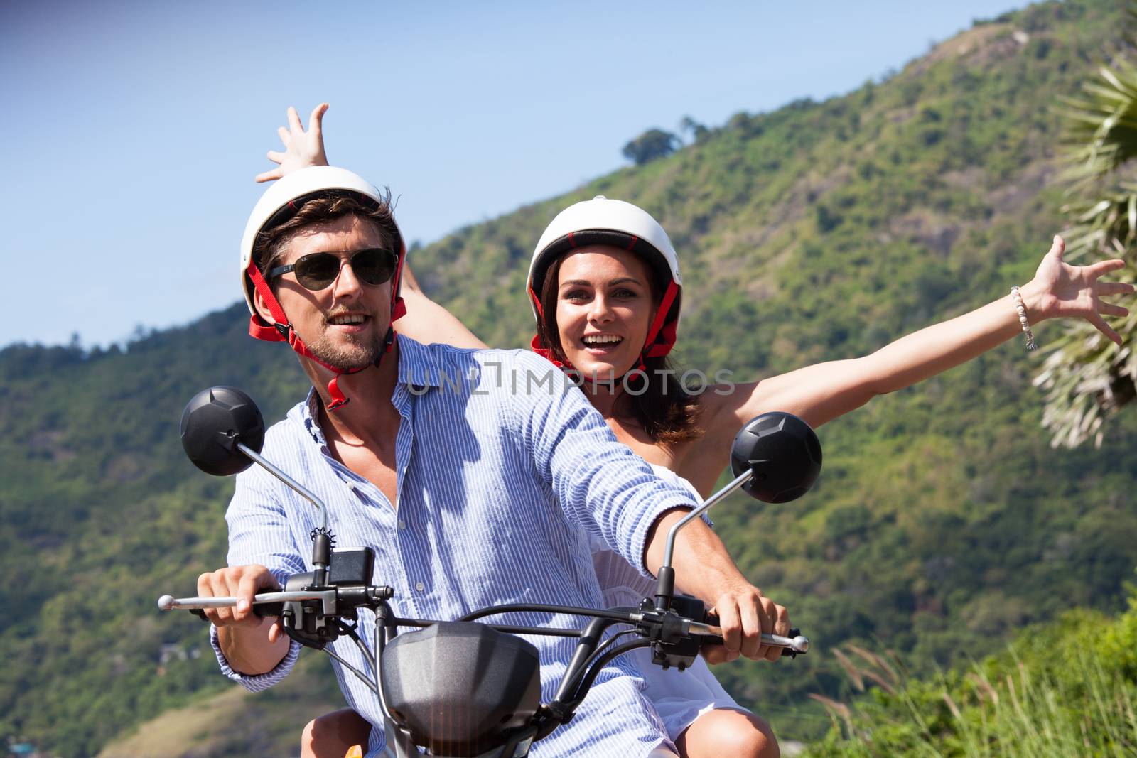 Happy couple on a scooter at summer vacation