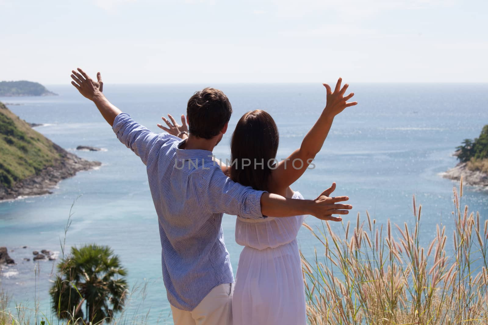 Young couple on vacation looking at sea together