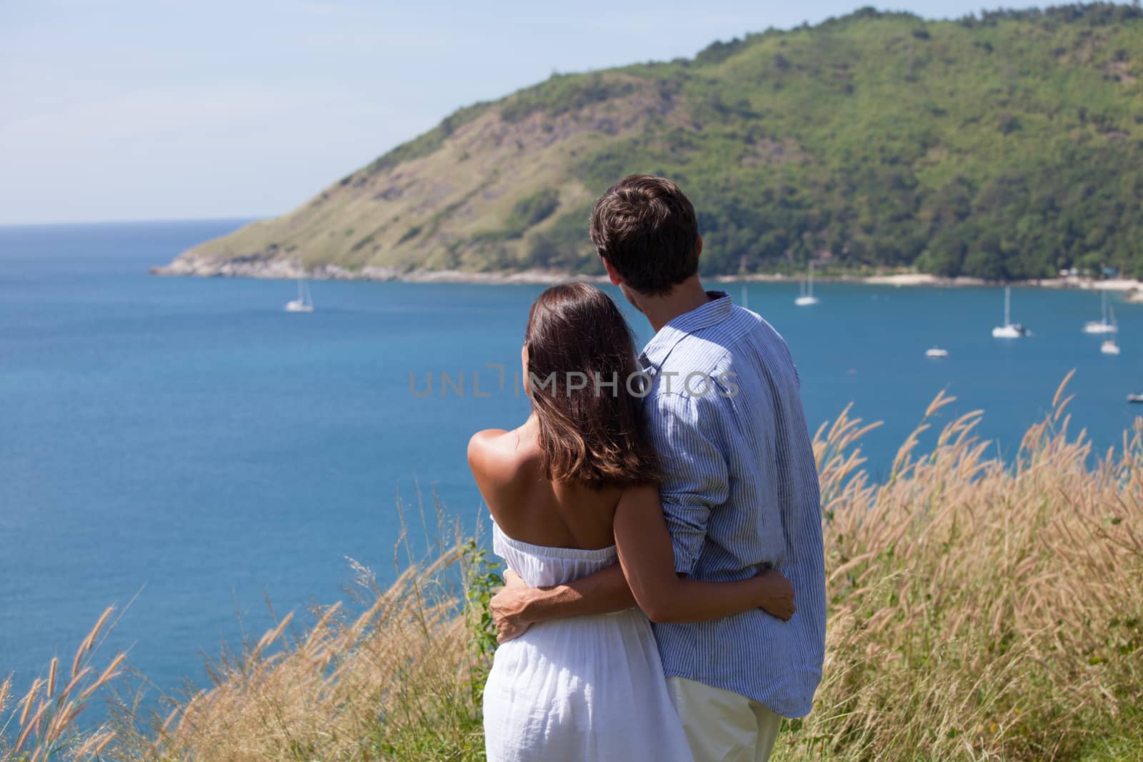 Young couple on vacation looking at sea together