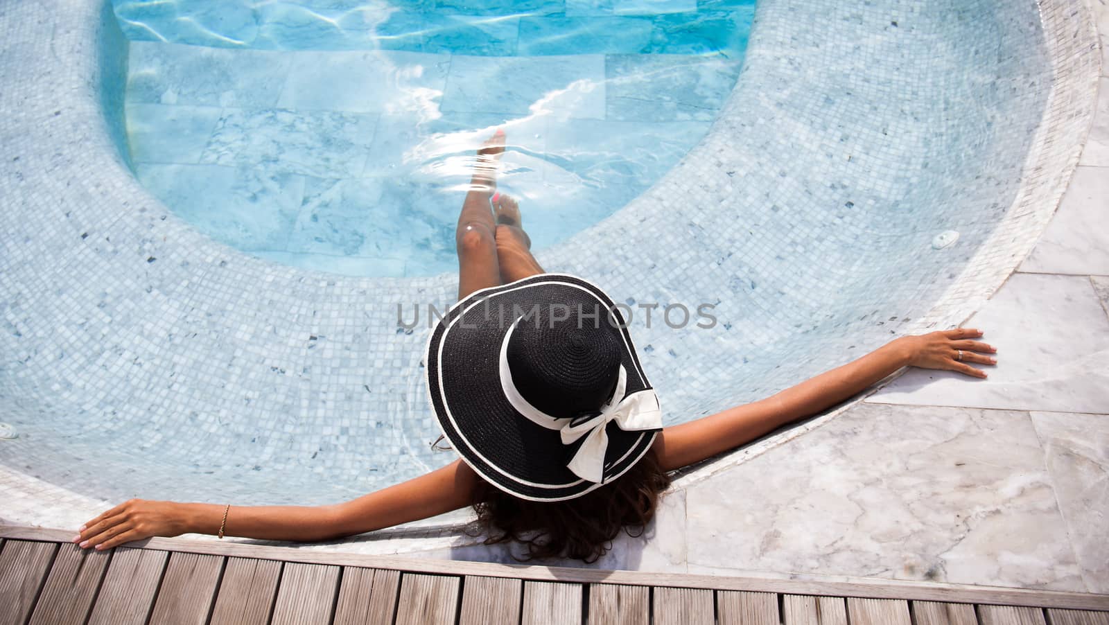 Beautiful woman relaxing at swimming pool at tourist resort