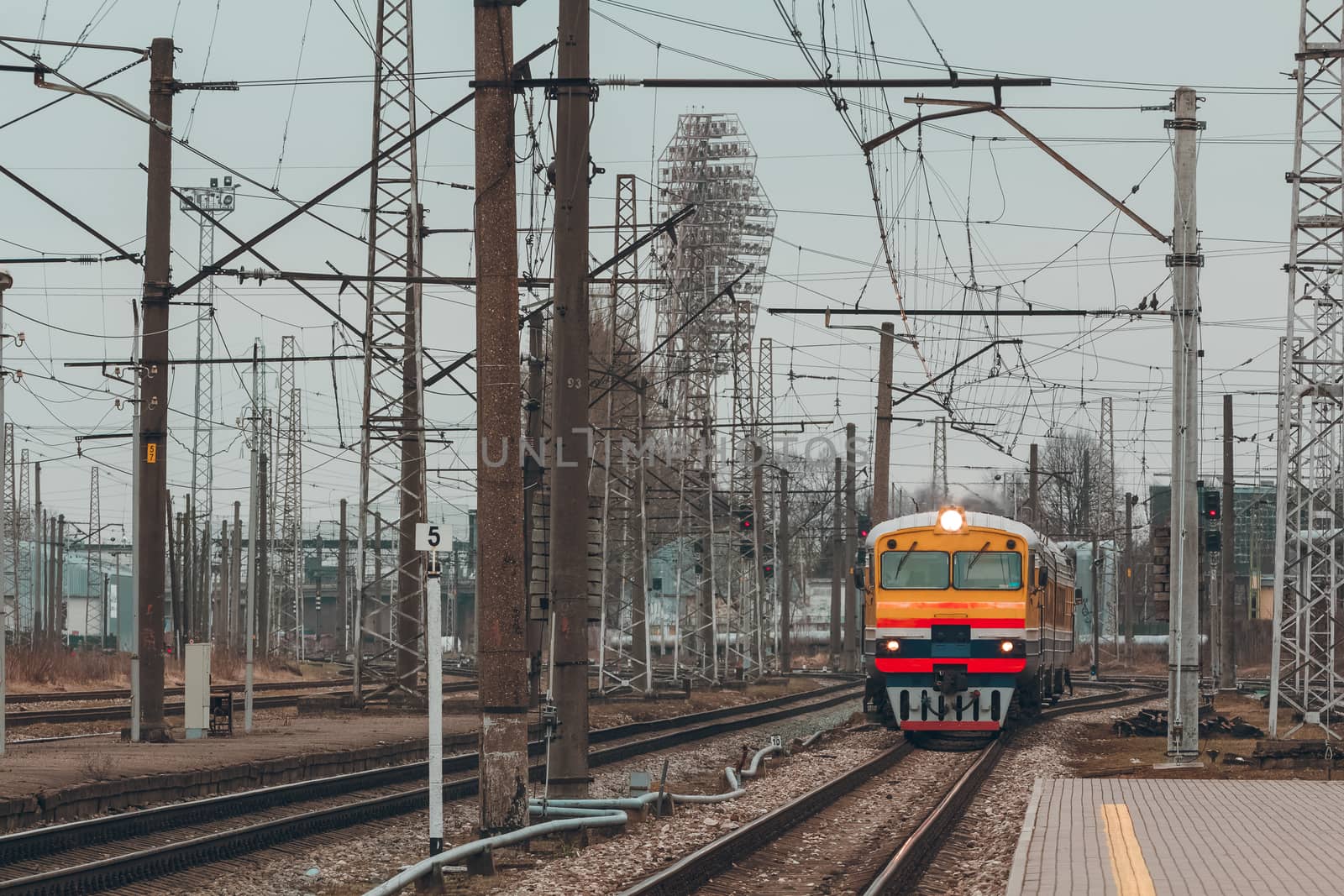 Old yellow passenger diesel train moving at the terminal