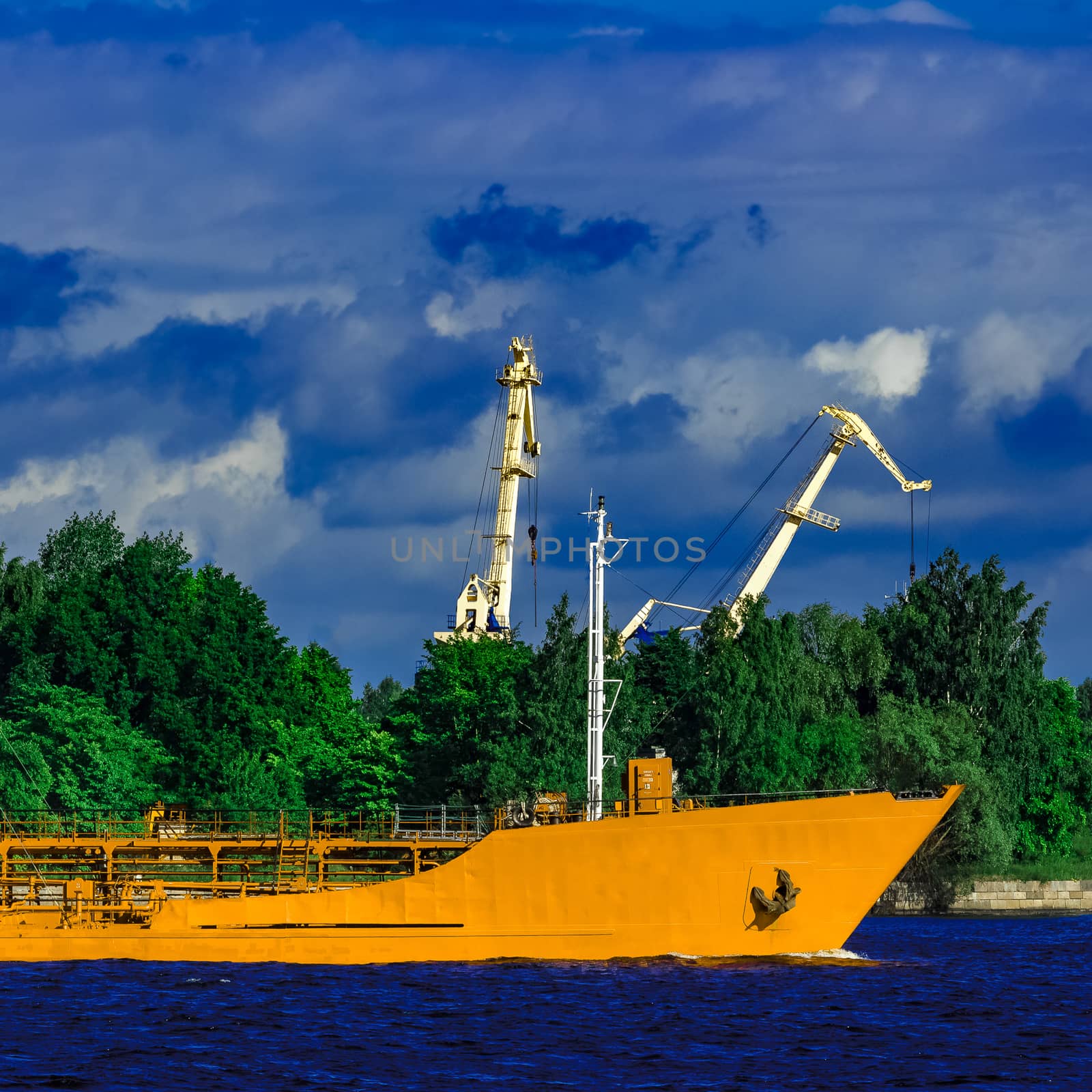 Yellow cargo tanker ship moving at the clear summer day