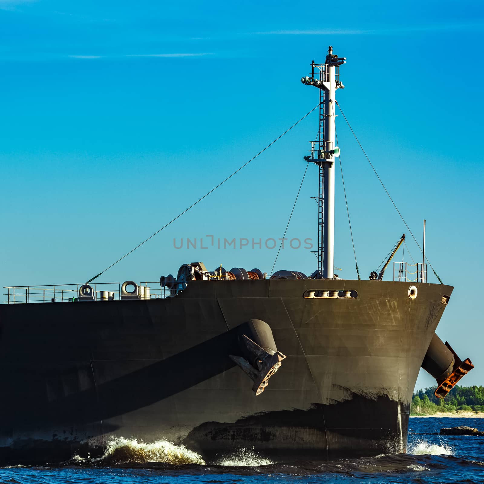 Black cargo ship moving to Baltic sea at clear day